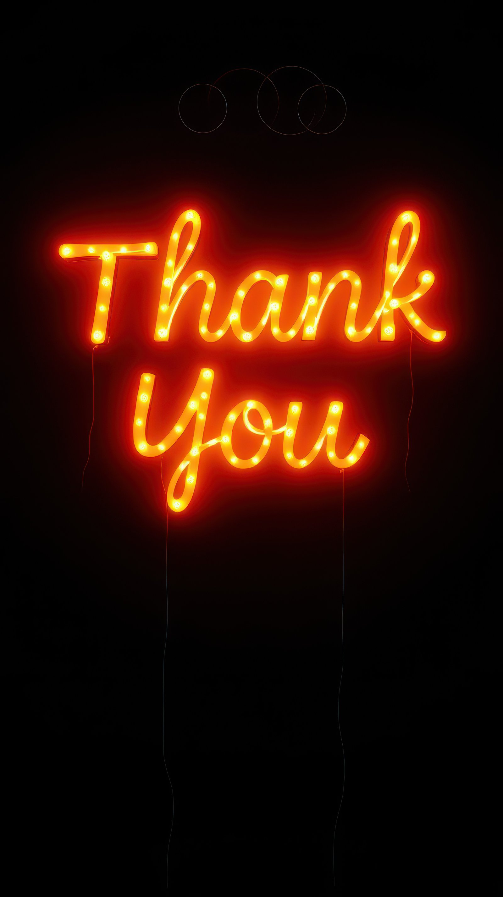 Neon lights create a vibrant thank you sign glowing in a dark space at night